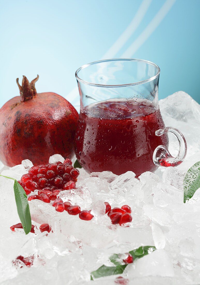Pomegranate juice and a pomegranate on ice