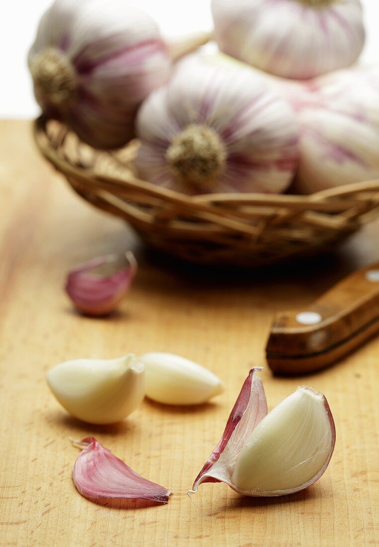 Garlic bulbs in a basket and peeled garlic cloves