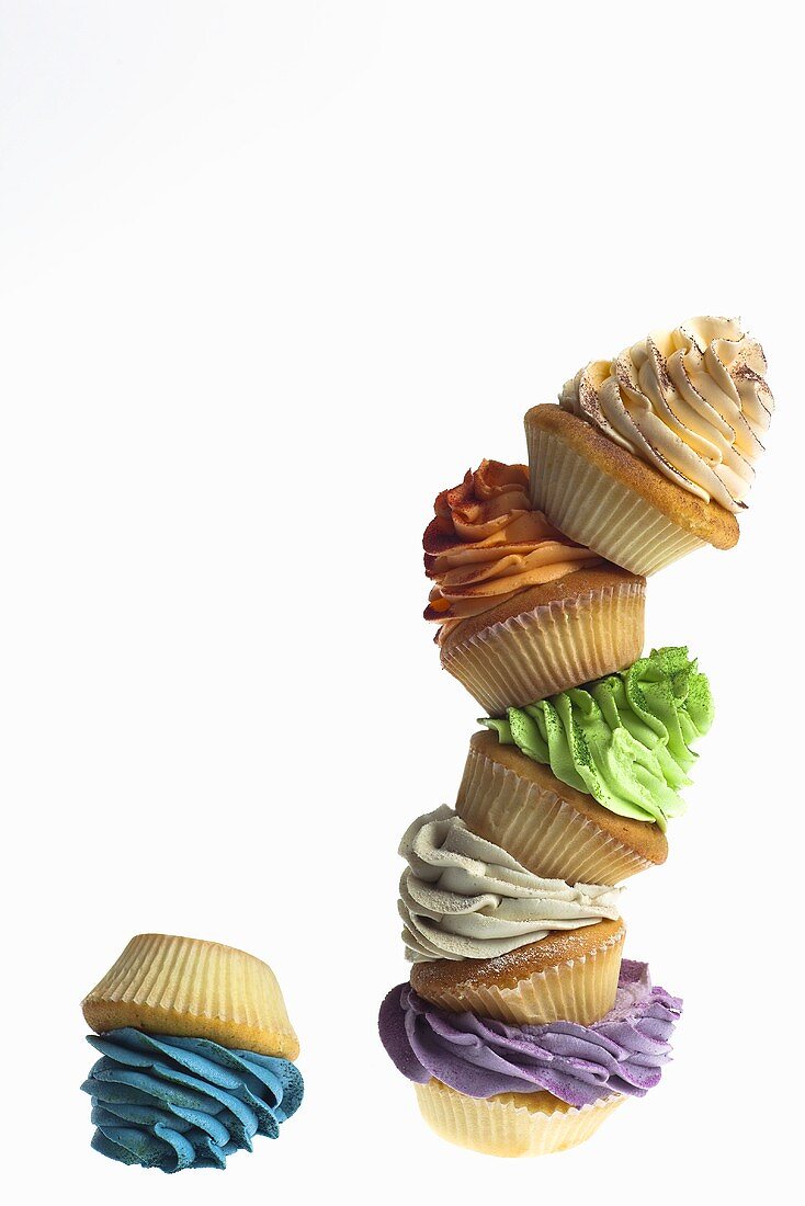 A stack of cupcakes decorated with coloured cream