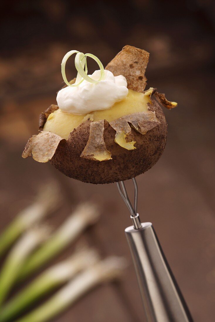 A semi-peeled potato with quark on a peeling fork