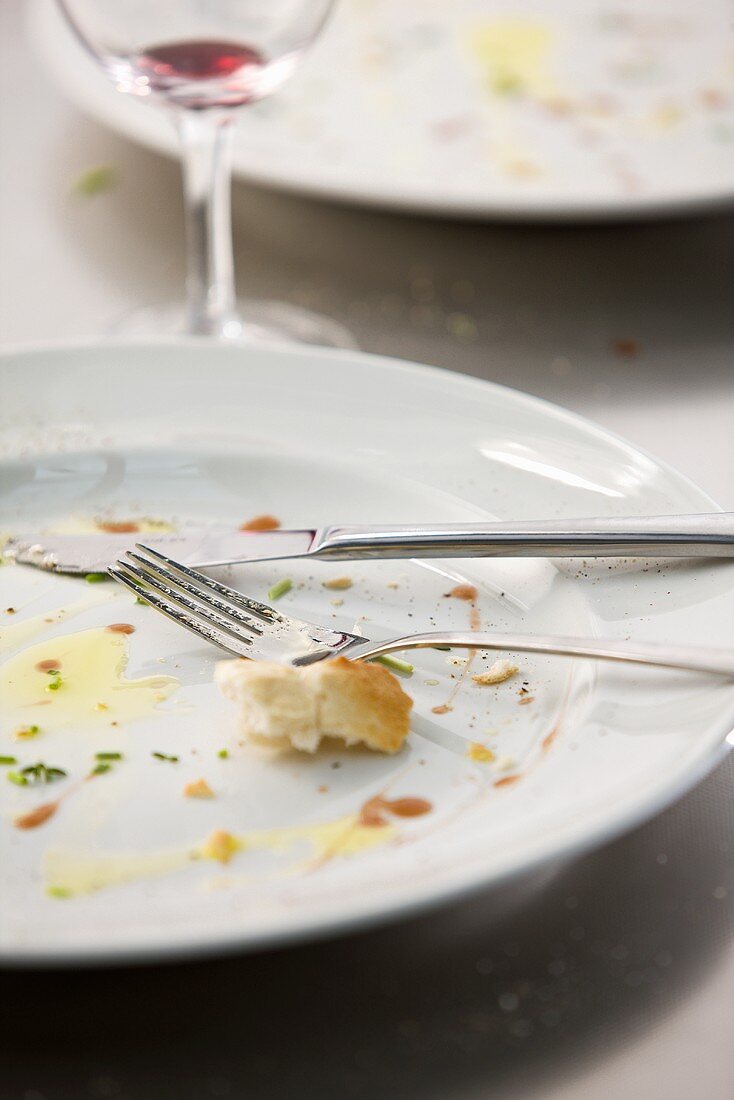 A plate with the remains of a baguette and olive oil