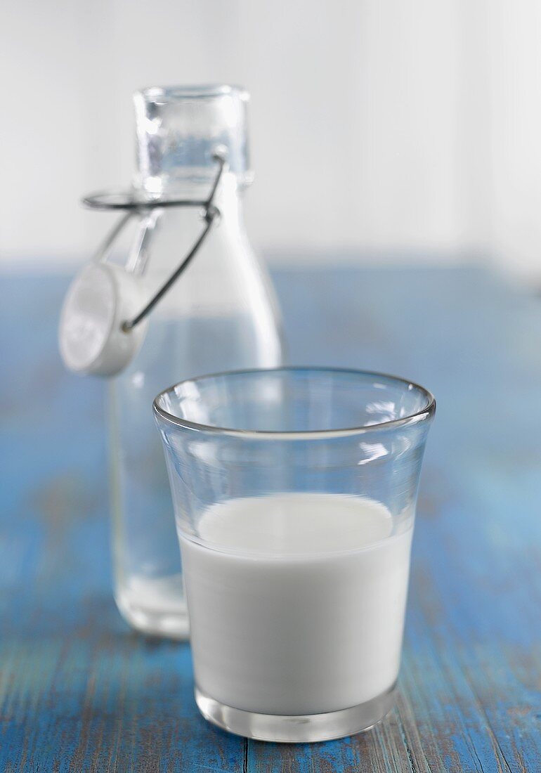 A glass of milk and a glass bottle