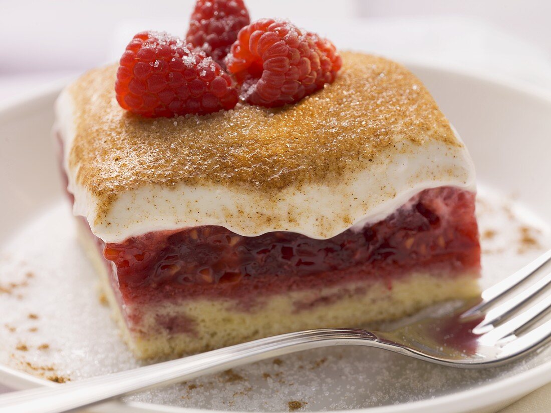 A piece of raspberry cake with sour cream-cream topping