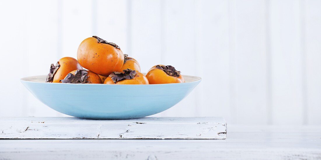 Several persimmons in a bowl