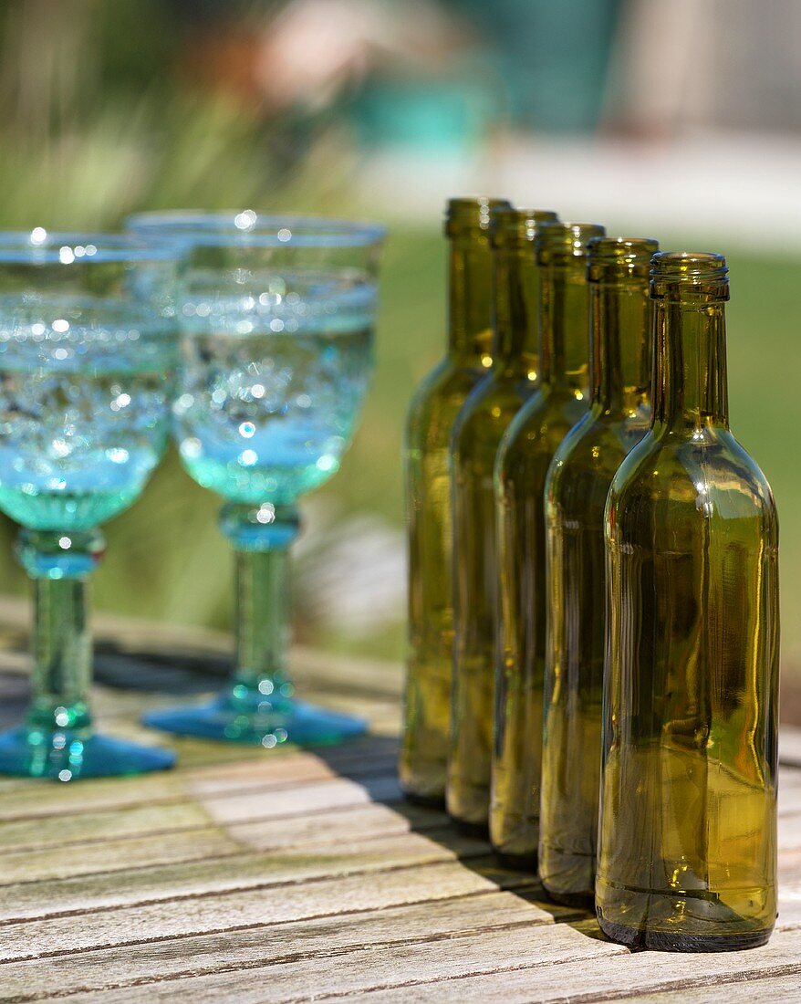 Leere Gläser und Flaschen auf einem Gartentisch