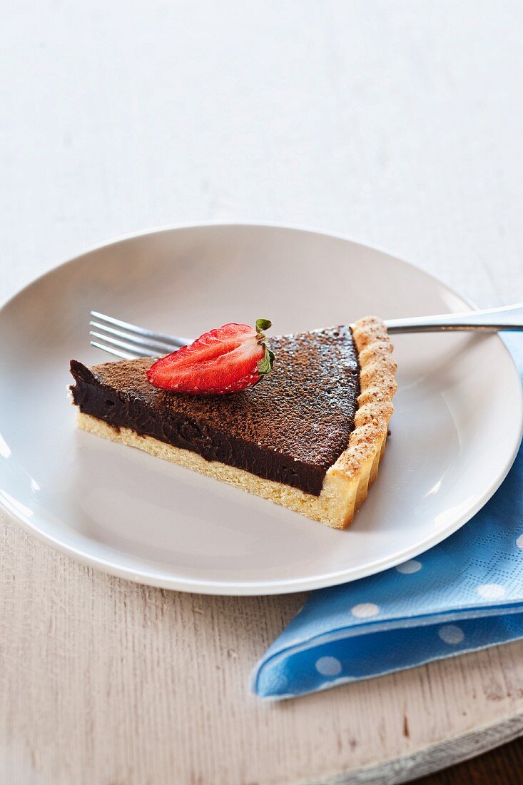 A slice of chocolate tart with strawberries