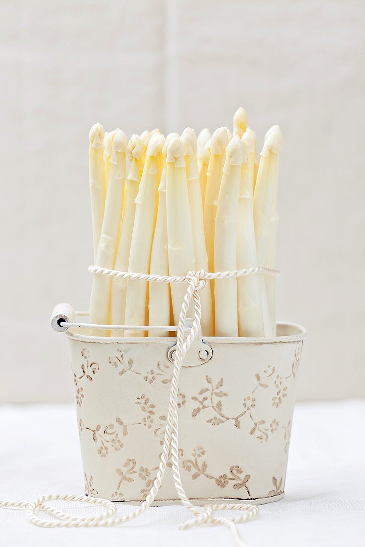 White asparagus spears in an old metal basket