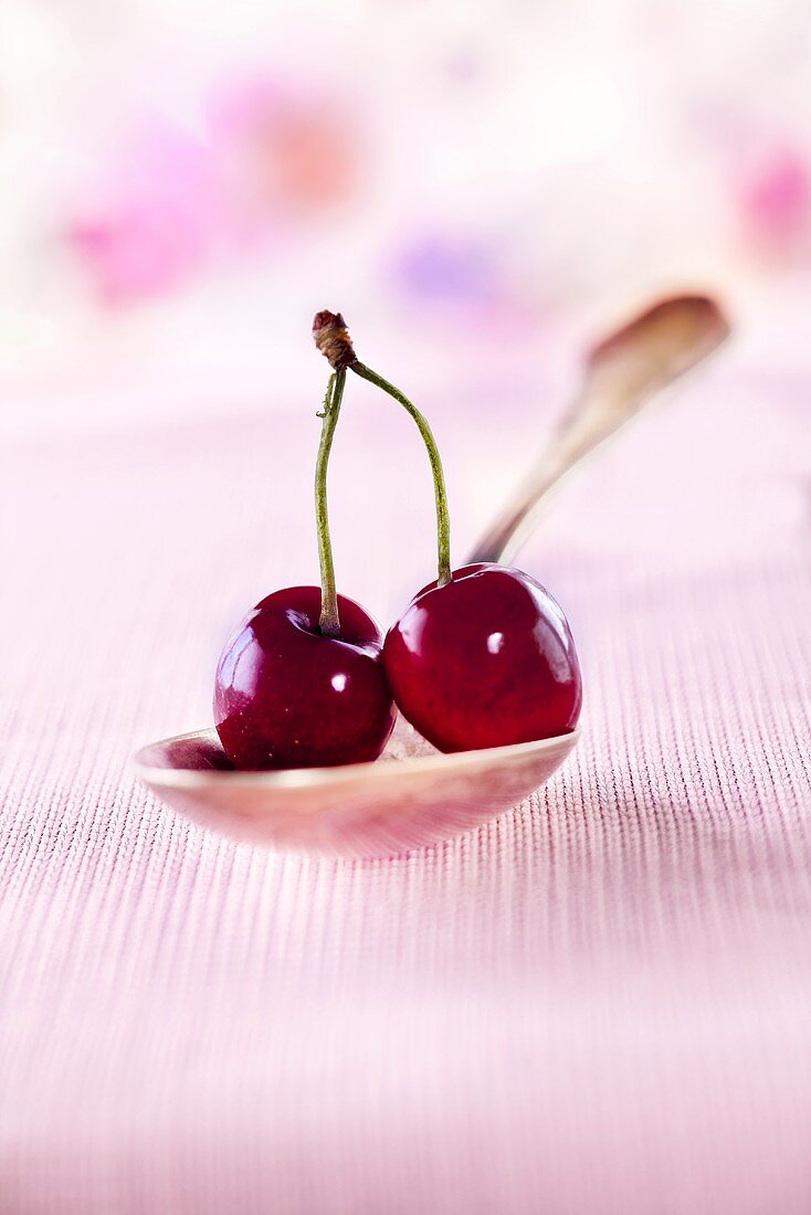 A pair of cherries on a spoon
