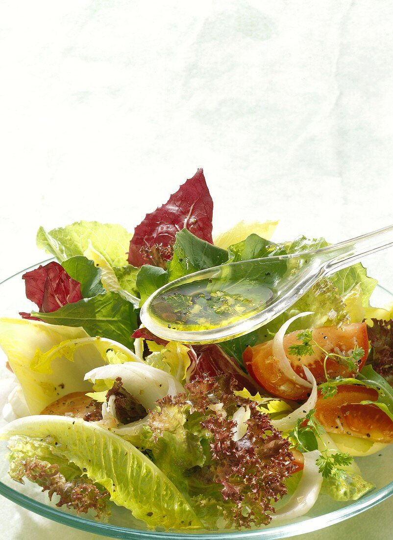 Vinaigrette über gemischten Salat geben