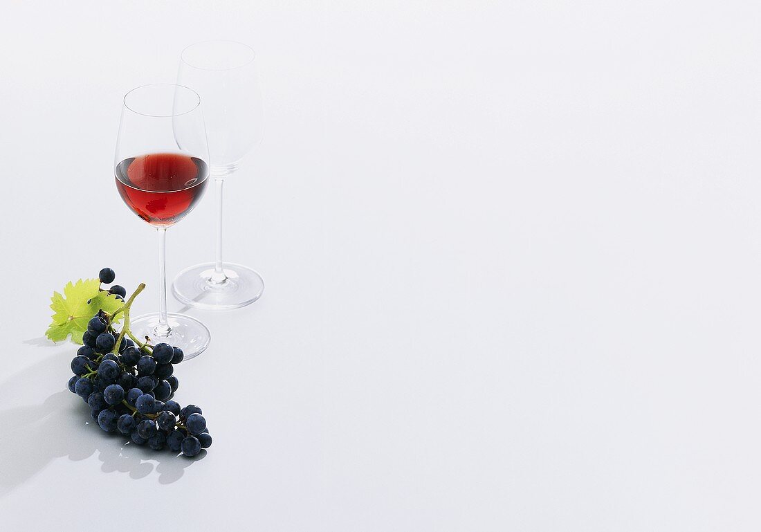Rotweingläser und Weintrauben