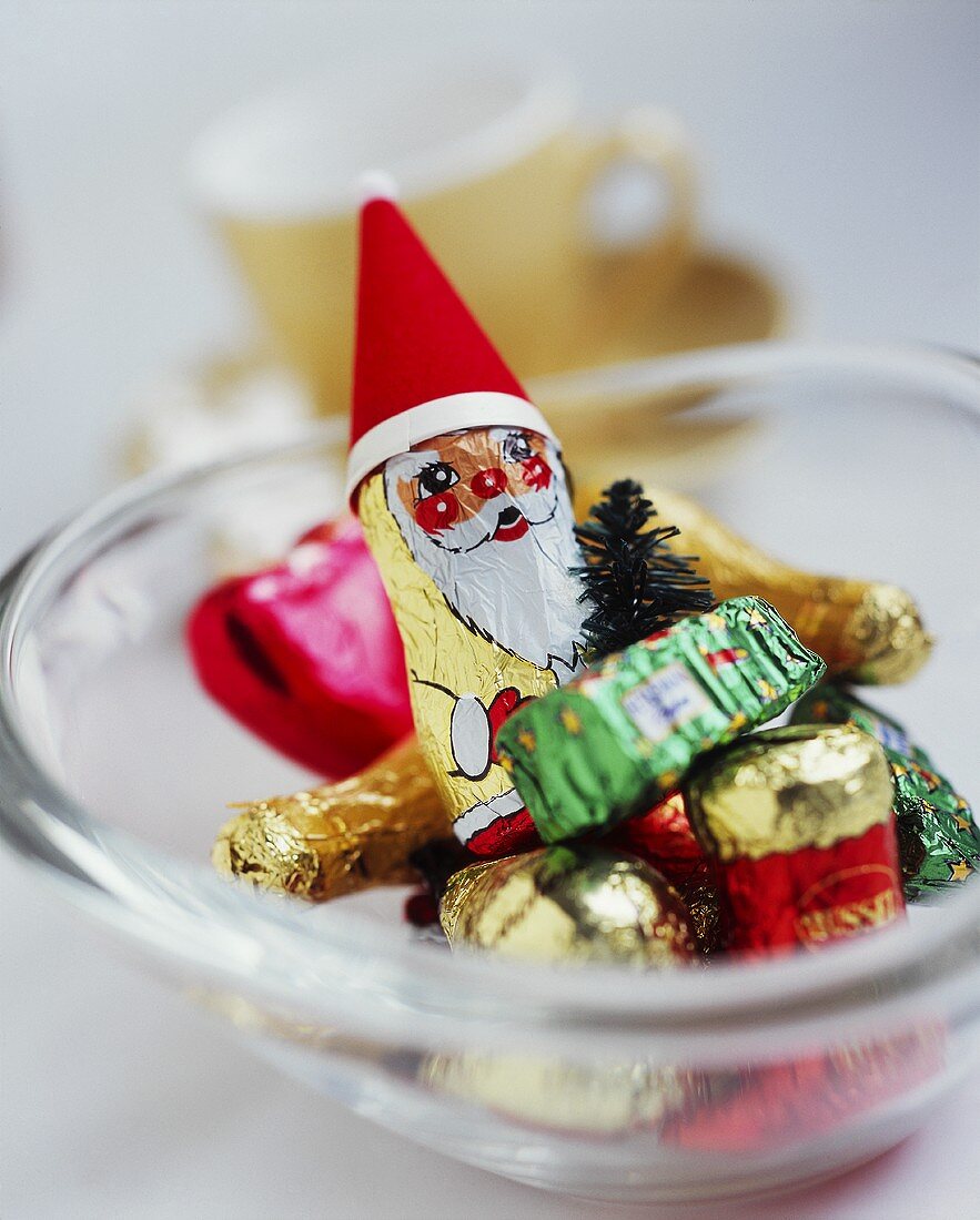 A glass bowl with a chocolate Father Christmas & other sweets