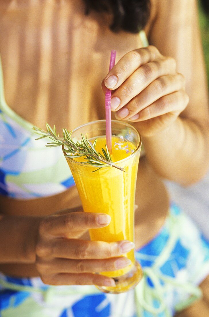 Young woman in bikini holding orange juice