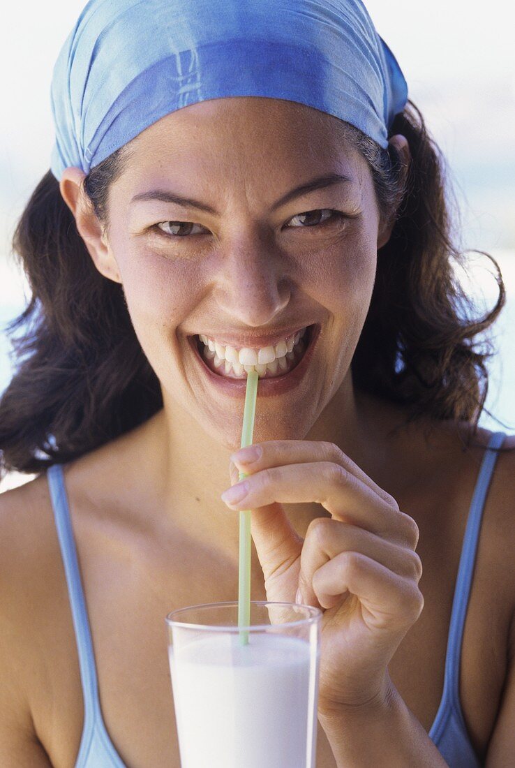 Young woman drinking milkshake through a straw