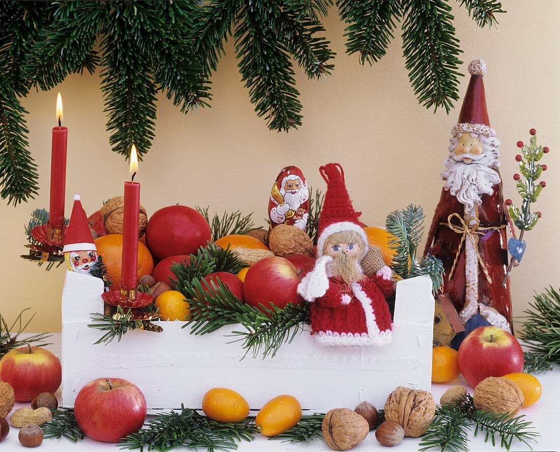 Weihnachtsdeko: Obst, Nüsse, Tannenzweige und Nikoläuse