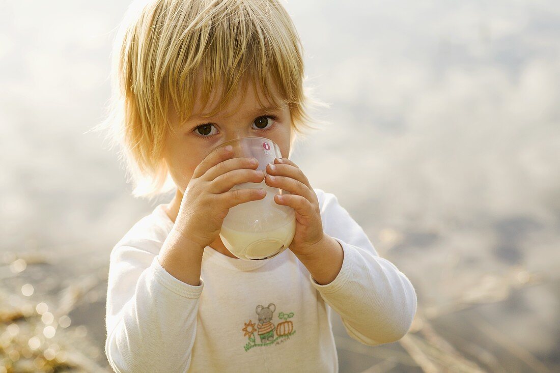 Kleiner Junge trinkt ein Glas Milch