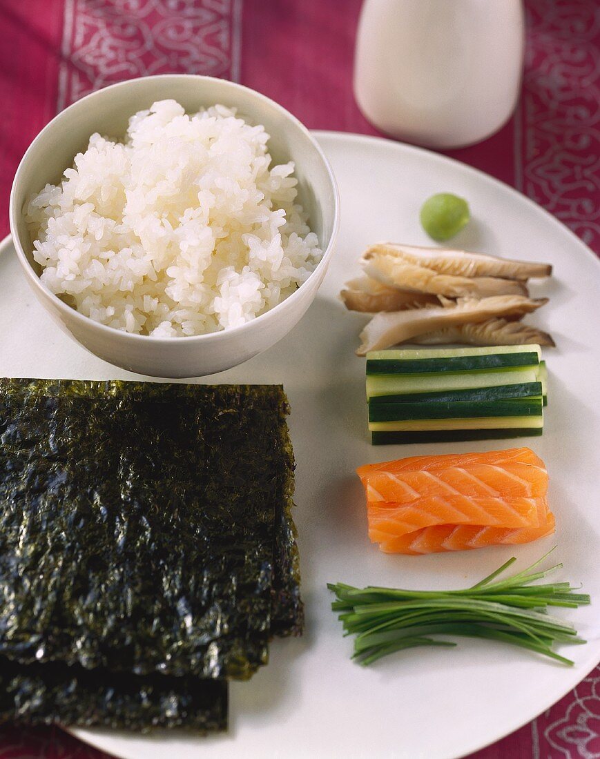 Zutaten für Sushi: Reis, Nori, Fisch, Gurken und Wasabi