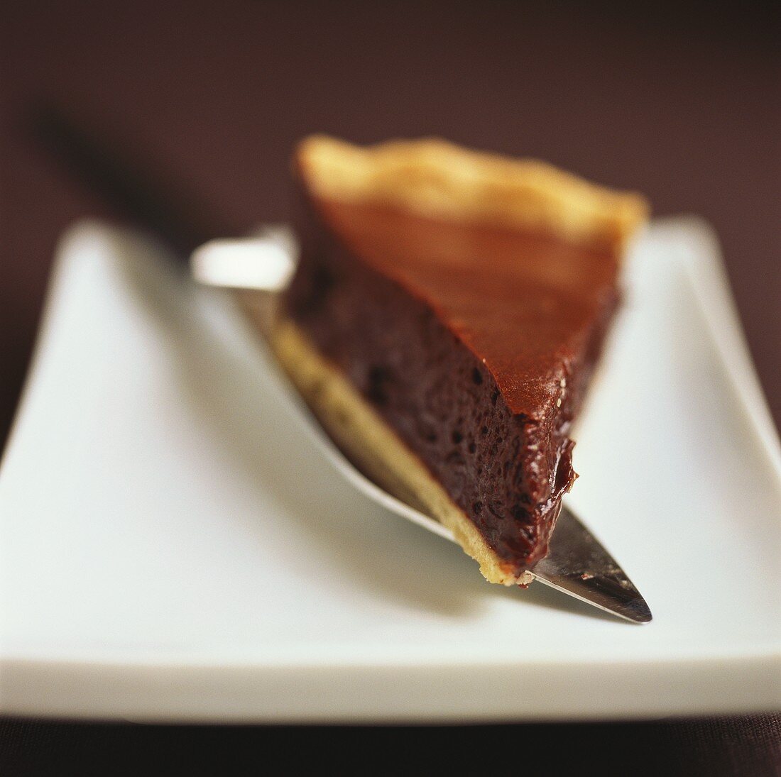 A piece of chocolate tart on server