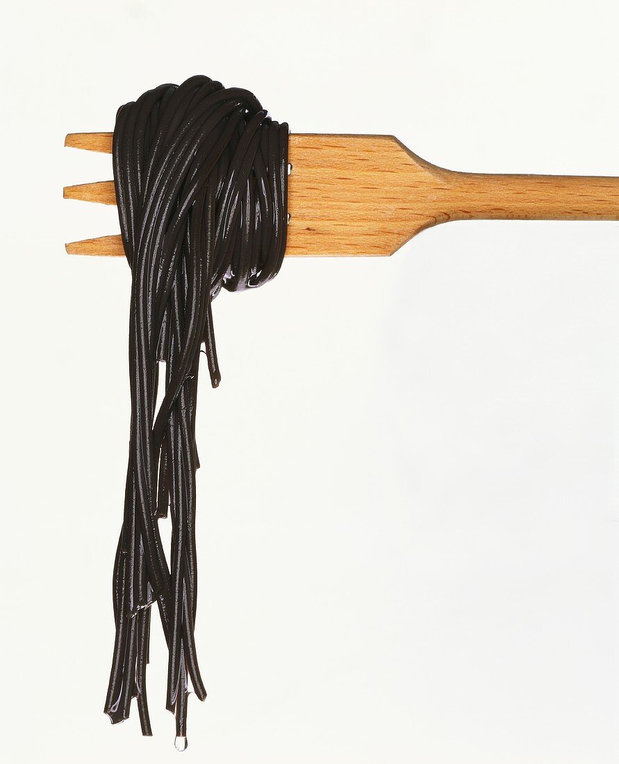 Gekochte schwarze Spaghetti auf Holzgabel