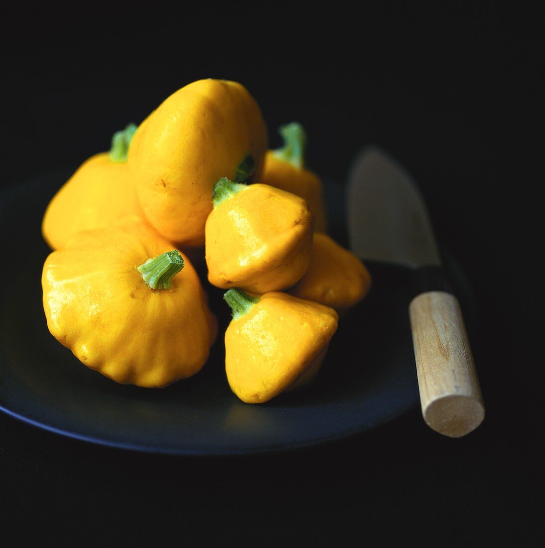 Patty pan squashes on plate with knife