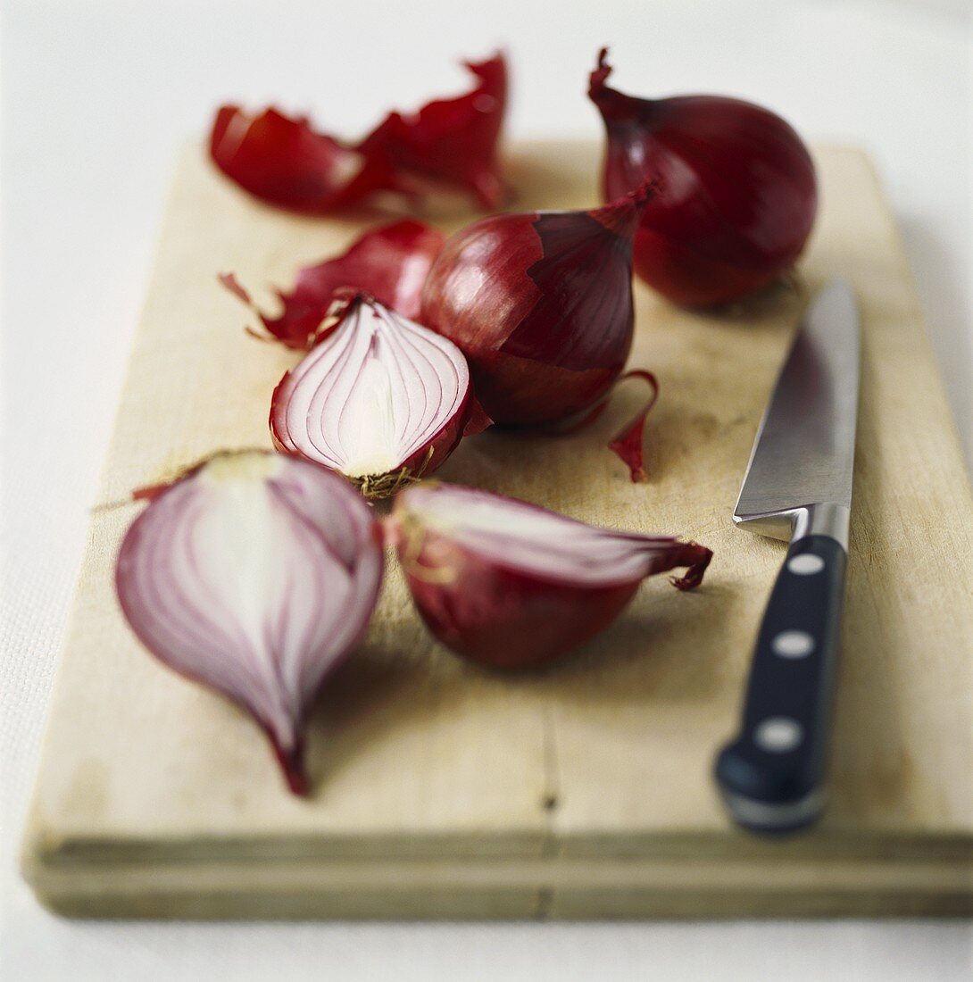 Red onions on chopping board with knife