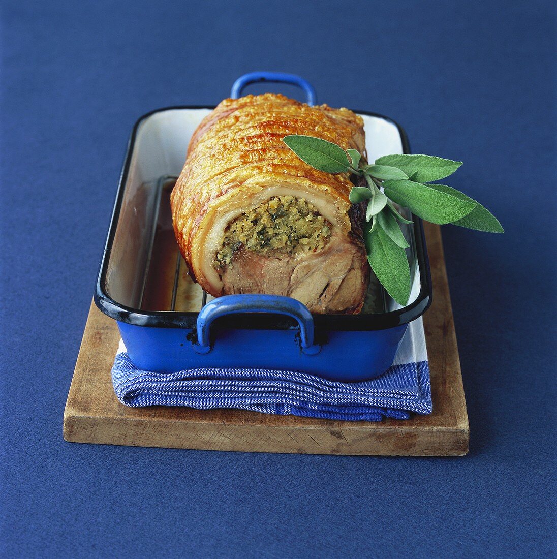 Stuffed rolled pork joint in roasting dish