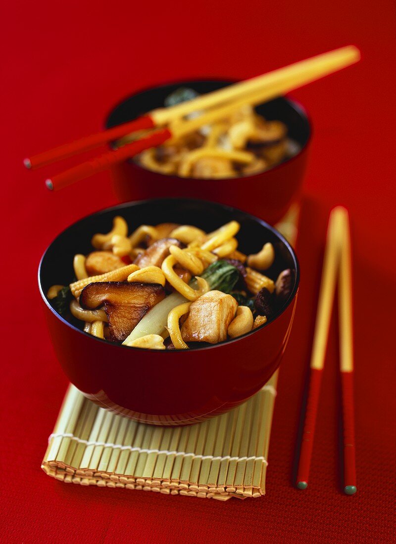 Fried noodles with chicken, vegetables and mushrooms