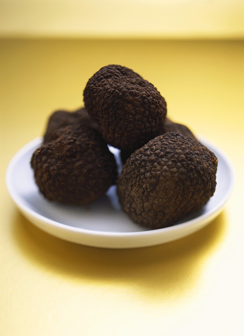 Black truffles on white plate