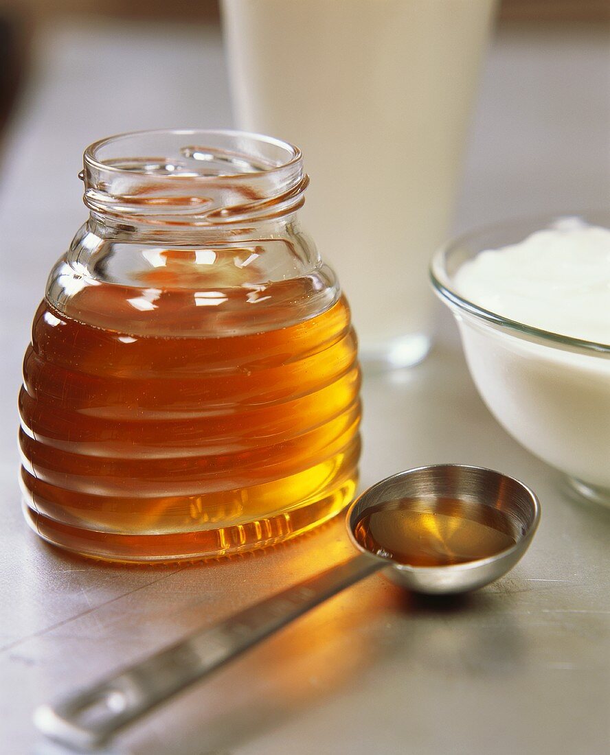 Honig im Glas und auf Löffel; Joghurt; Milch