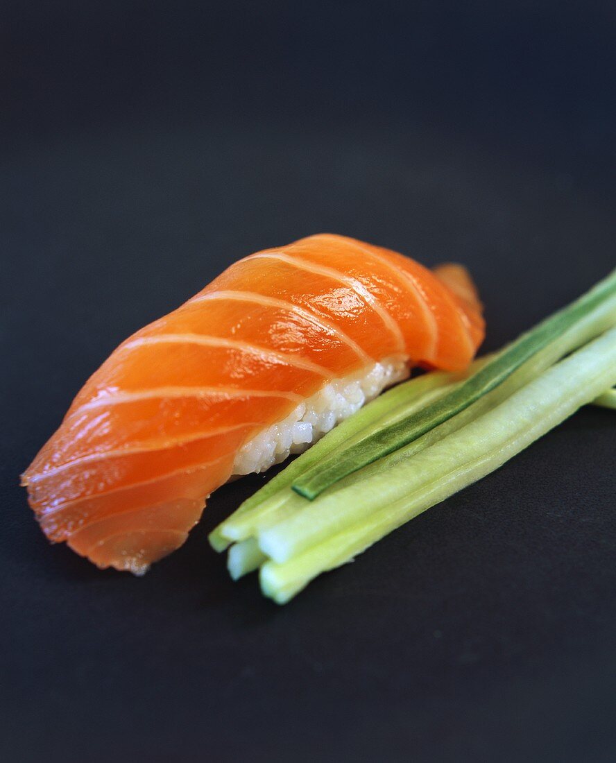 Nigiri-sushi with salmon; strips of cucumber