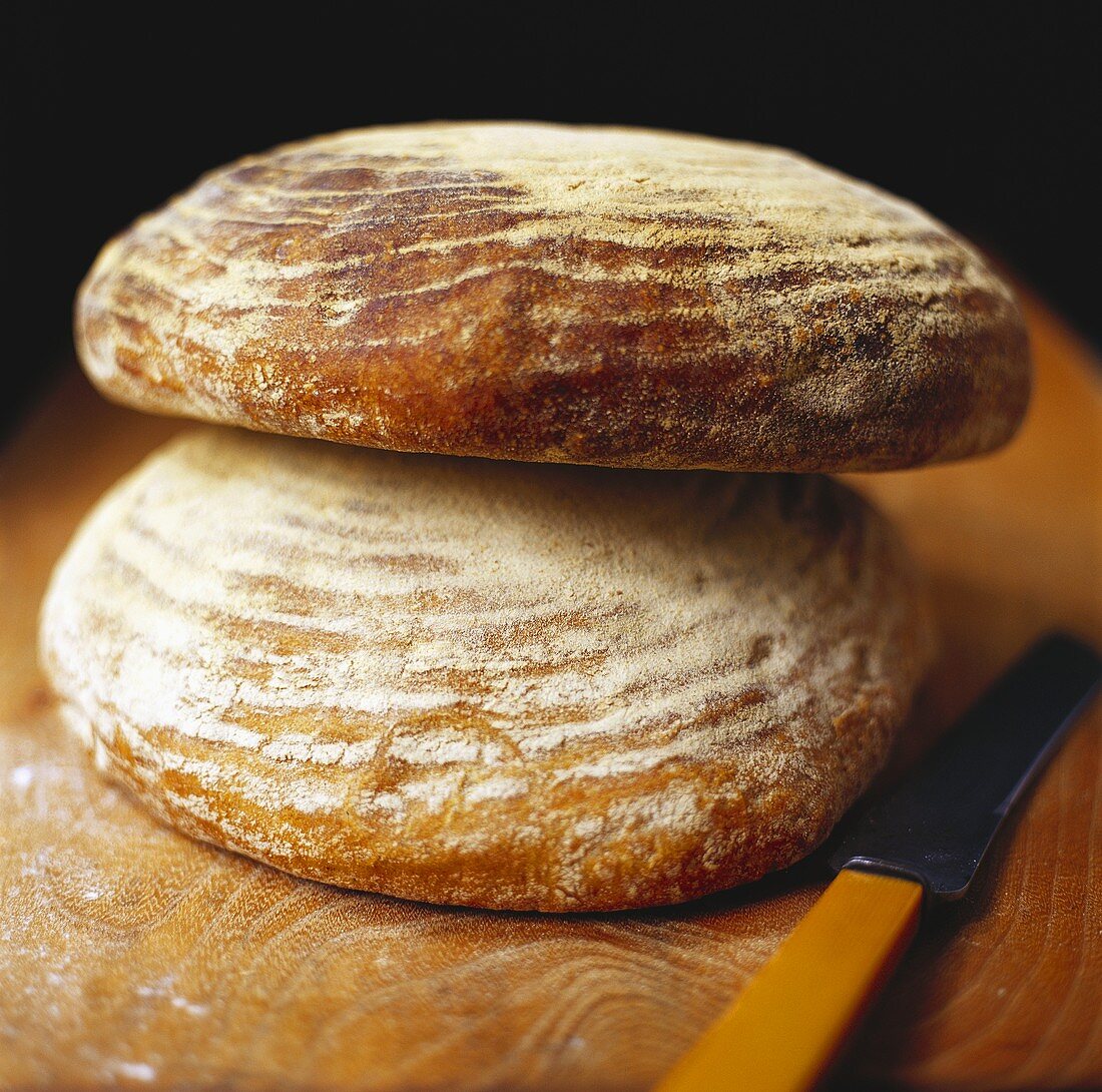 Two loaves of bread on wooden background