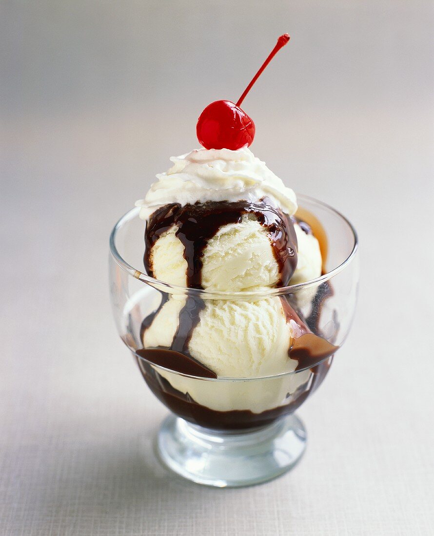 Vanilla ice cream with chocolate sauce, cream & cherry