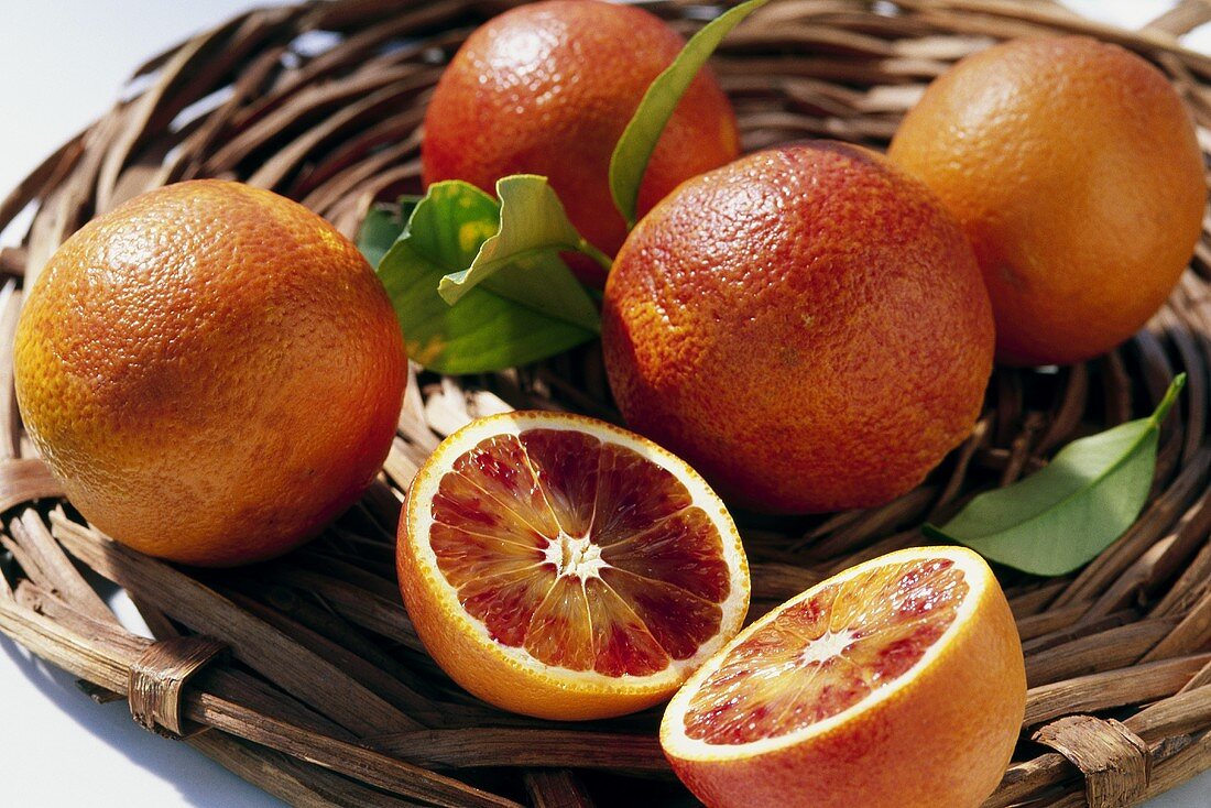 Blood oranges, variety: Sanguinello (Citrus sinensis), in basket