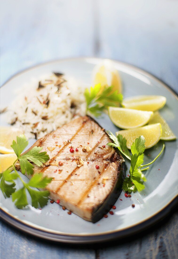 Tuna steak with rice, limes and coriander leaves