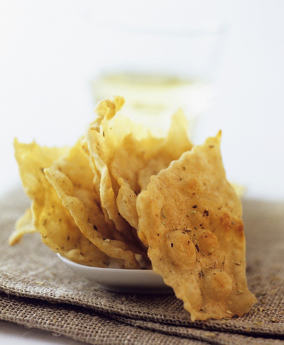 Pieces of flatbread in front of glass of white wine