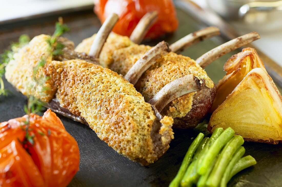 Racks of lamb with cheese coating and roasted vegetables
