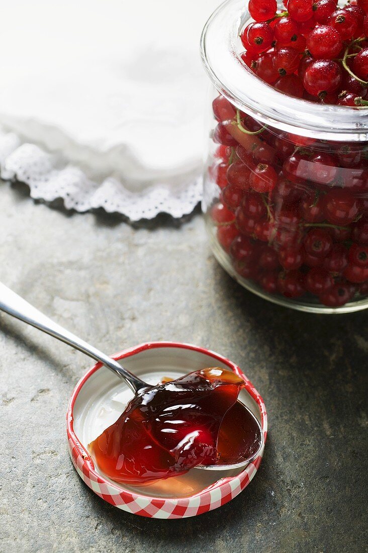 Rote Johannisbeeren im Glas, Johannisbeergelee auf Löffel