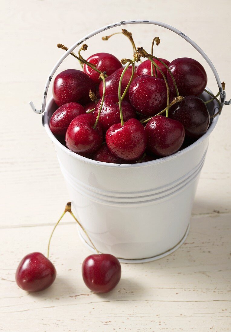 Cherries in and beside bucket