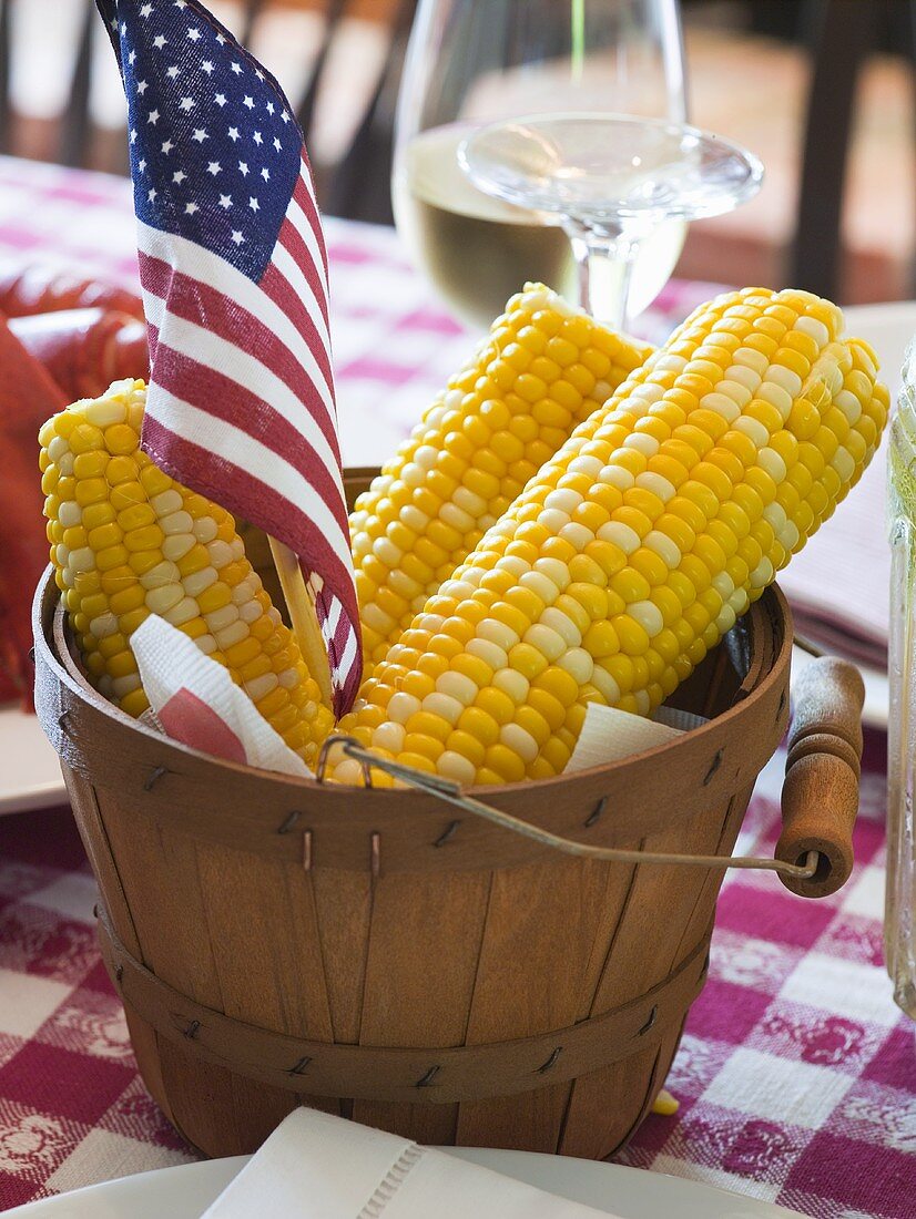 Corn cobs with American flag on laid table (USA)