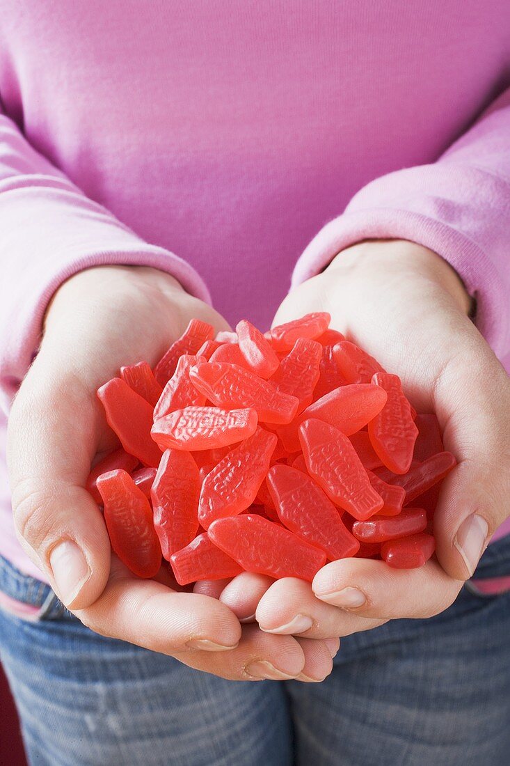 Hands holding many Swedish Fish (sweets, … – License Images – 853253 ❘  StockFood