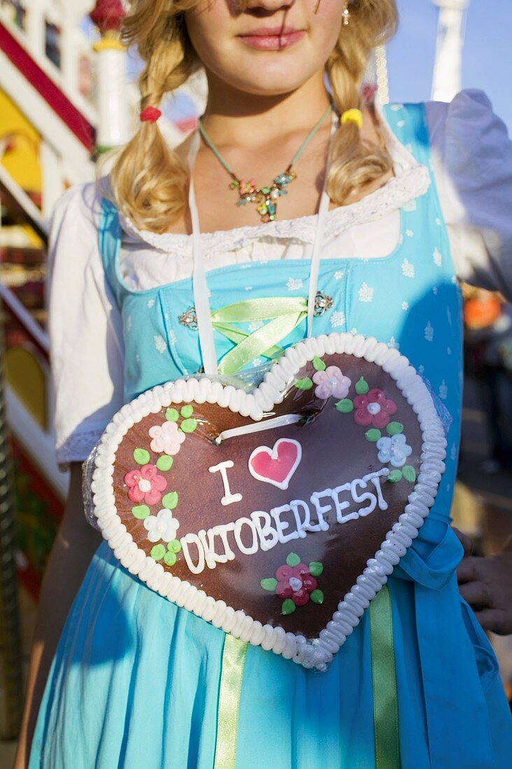 Girl with Lebkuchen heart at Oktoberfest in Munich