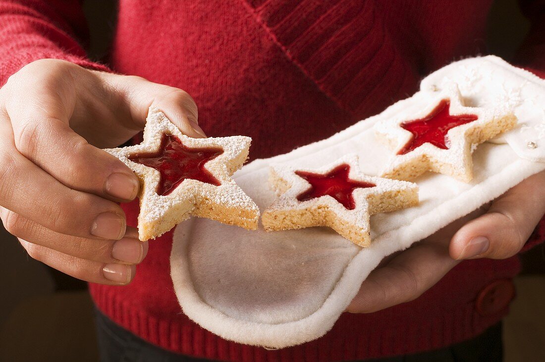 Hände halten Marmeladenplätzchen auf weißem Stiefel