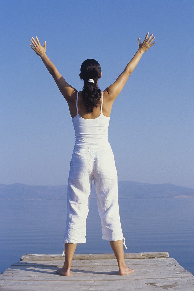 Woman in yoga posture by the sea