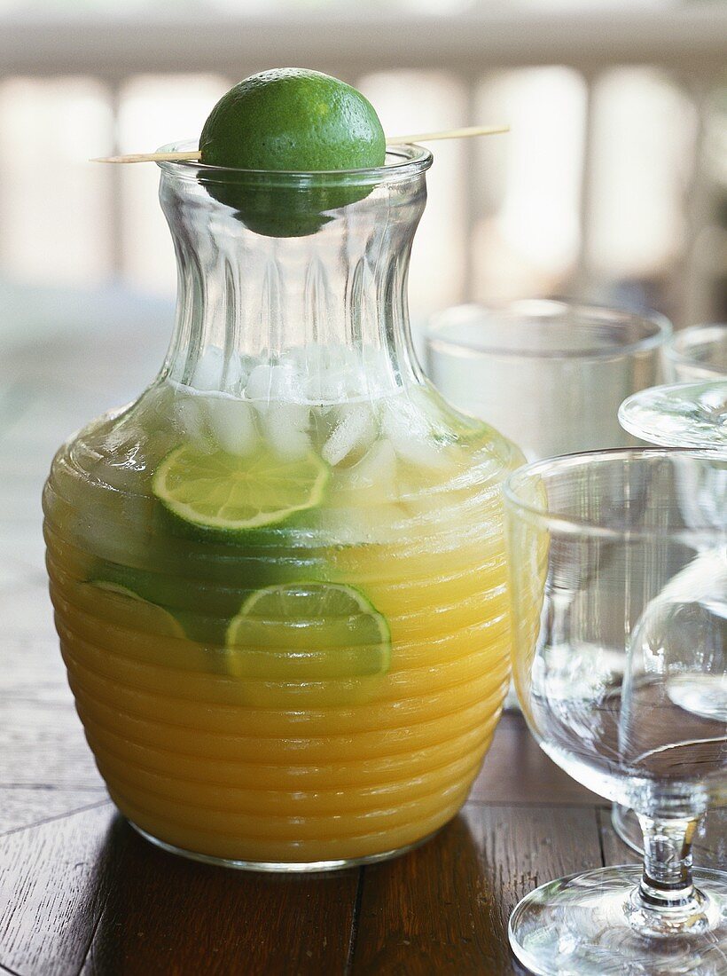 Lemonade with slices of lime in a glass jug