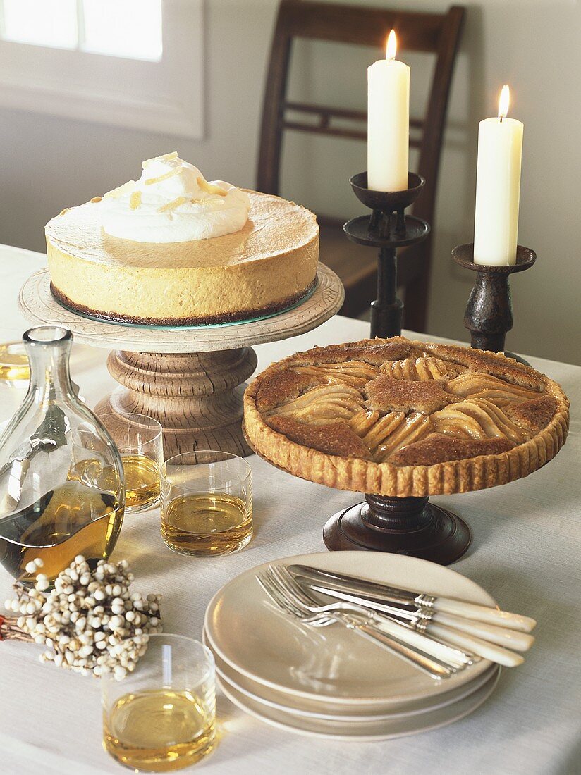 Cheesecake, pear tart and brandy on laid table