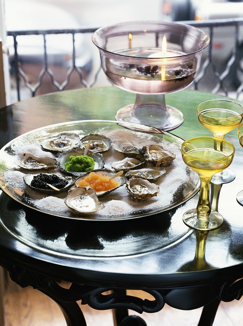 Fresh oysters and caviar on platter with salt