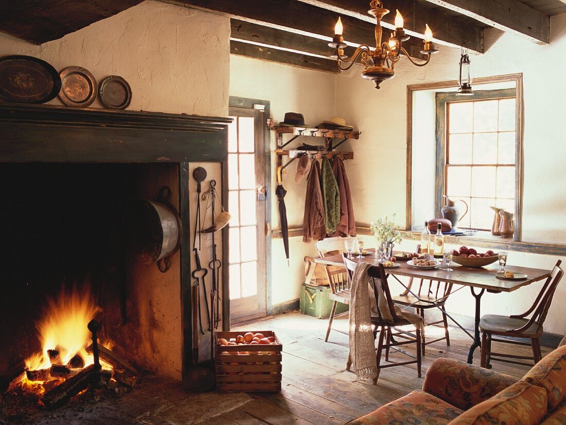 Rustic room with dining table, open fire and sofa
