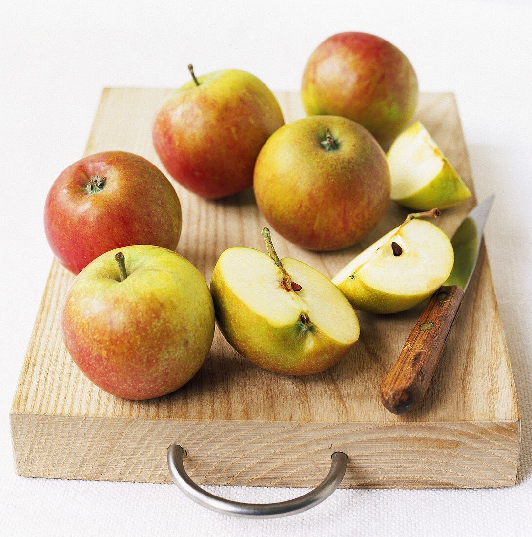 Äpfel mit Messer auf einem Holzbrett