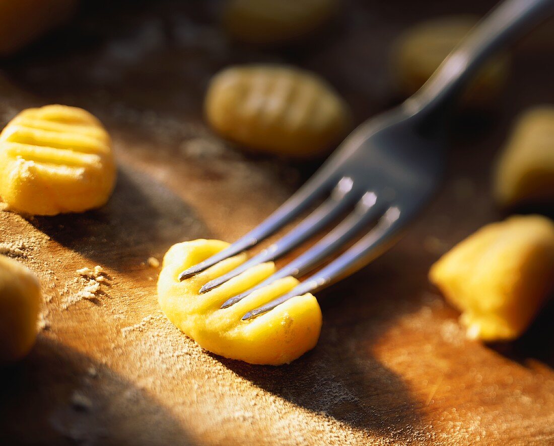 Pressing grooved pattern into gnocchi with fork
