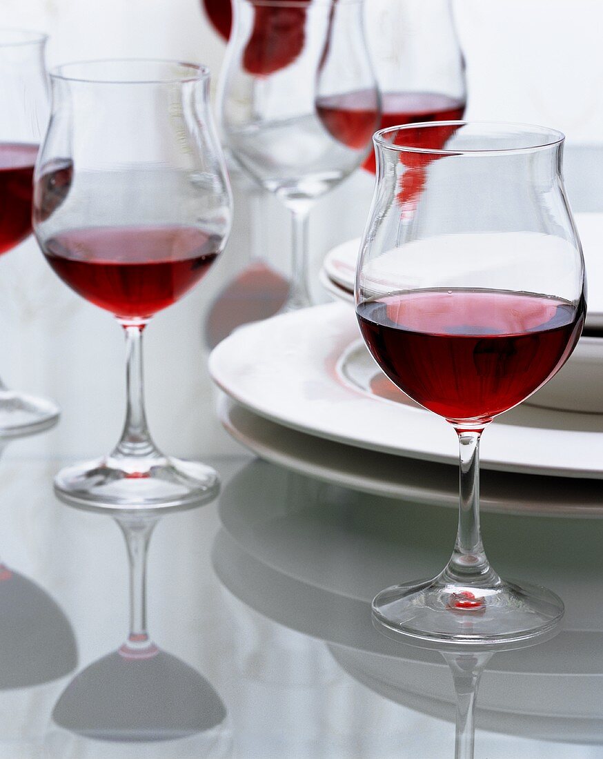 Tisch mit Rotweingläsern und Tellern