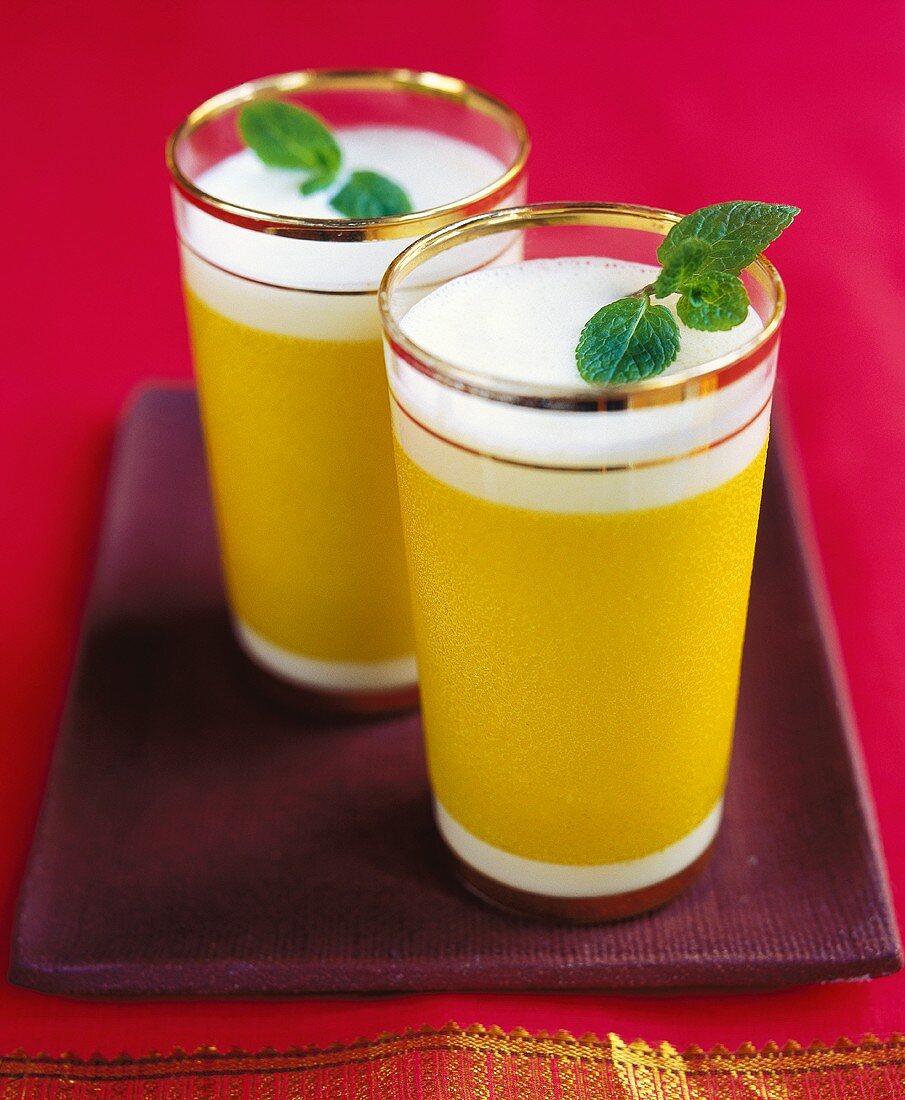 Zwie Gläser Mango-Lassi (indisches Mango-Joghurt-Getränk)